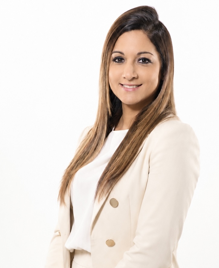 Zeenat Gopaul wearing a cream suit and smiling warmly.